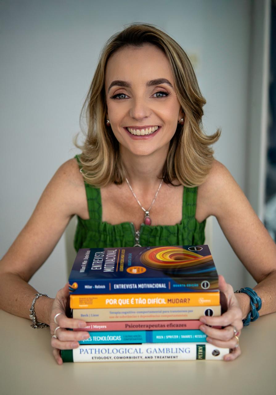 Ana Carolina com livros de referência em TCC e jogo patológico
